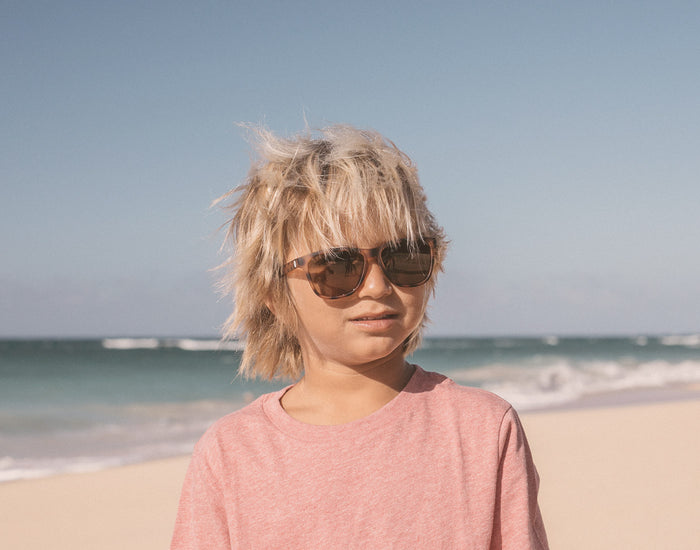 STORY boy on the beach wearing sunski mini madrona sunglasses