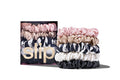 A set of five Slip silk midi scrunchies in various colors including black, pink, caramel, white, and navy stripe. Displayed stacked in front of branded packaging on a white background.