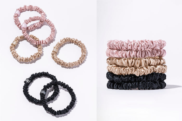 Flatlay of a set of six slip silk skinny scrunchies in pink, caramel, and black scattered and stacked on a white background.