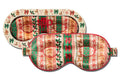 Holiday themed contour sleep mask with a festive Christmas pattern of gingerbread men, ornaments, and snowflakes in red, green, and peach, shown on a plain white background.