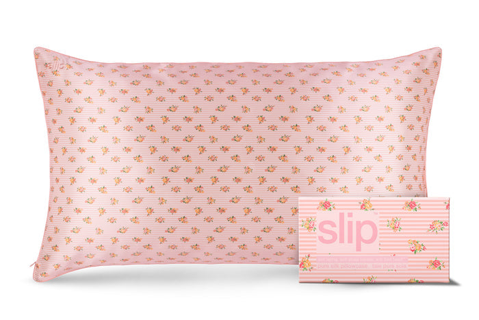 A king-sized silk pillowcase with a pink floral pattern with matching slip packaging on a white background.