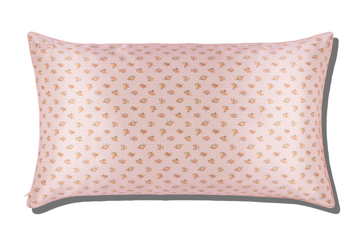 A king-sized silk pillowcase with a pink floral pattern on a white background.