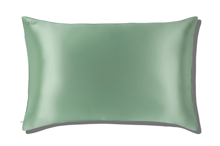 A green queen-sized zippered pillowcase with pistachio piping on a white background.