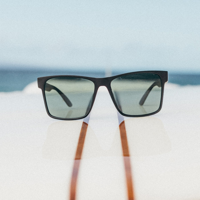 Sunglasses with wooden arms on a blurred beach background