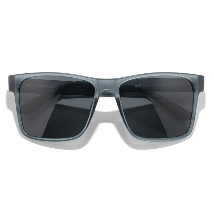 Sunglasses with gray frame and dark lenses on a white background