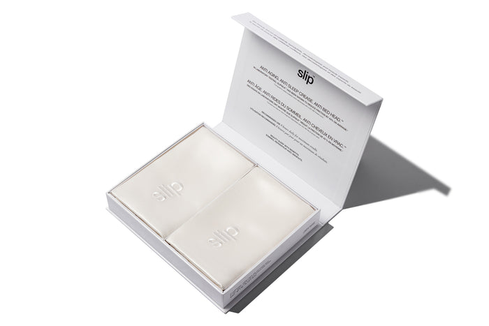 White slip silk queen pillowcases branded packaging on a white background.