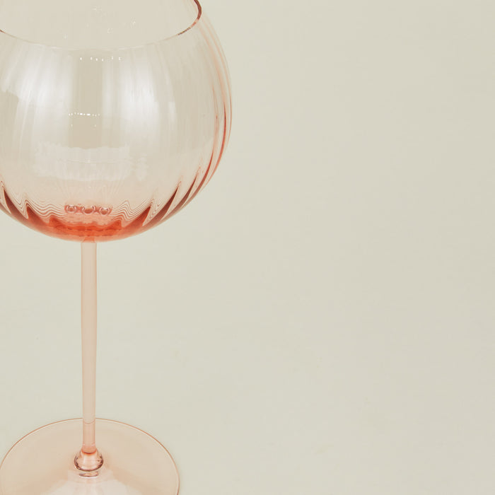 Close up of ribbed blush wine glass.