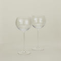 Set of two ribbed clear wine glasses.