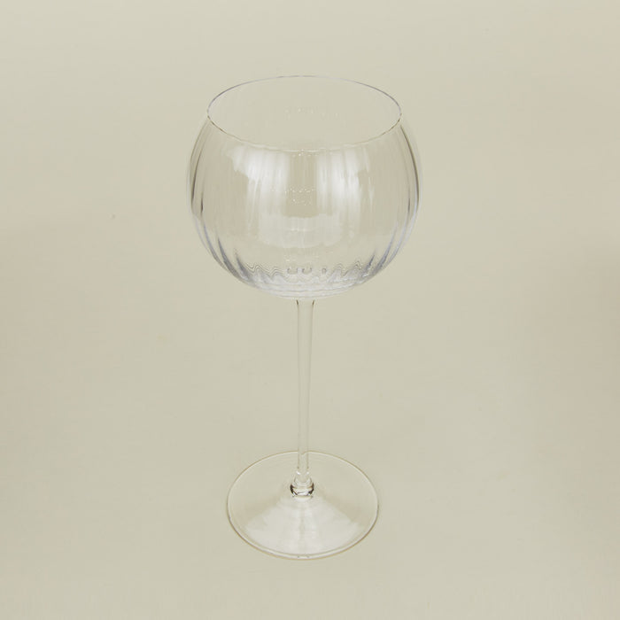 Three-quarter angle of ribbed clear wine glass.