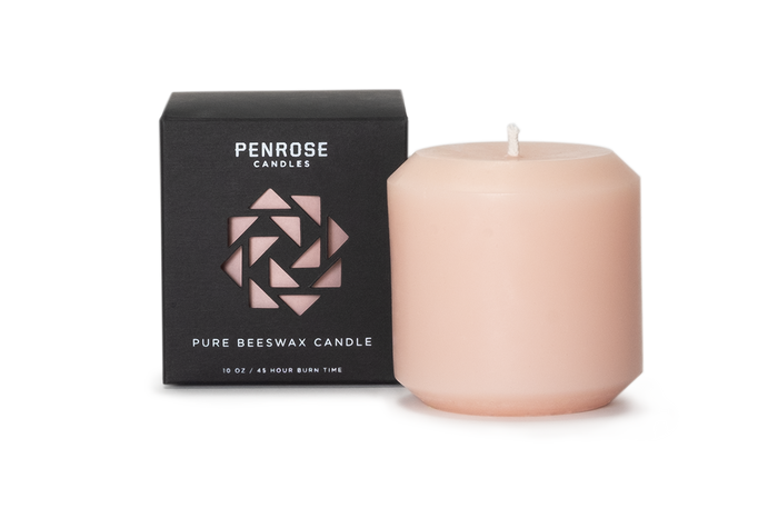 A pink 3 inch pillar candle made from pure beeswax, displayed alongside its black packaging with the brand name 'Penrose' and the product name 'Pillar Candle' in minimalist design.