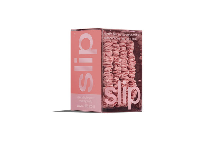 Blush pink silk skinny scrunchies in slip packaging on a white background.