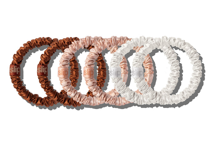 Six skinny silk scrunchies in dusk, desert rose and white on a white background.