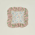 A ruffled floral cushion with a peony pattern.
