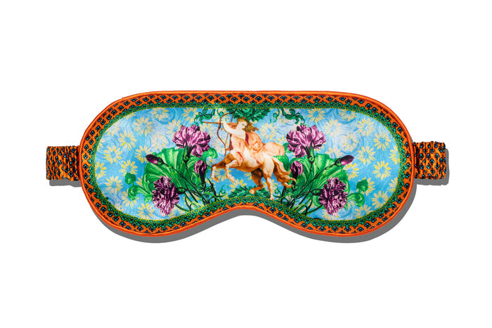 A slip silk sleep mask with a floral and horse pattern on a white background.