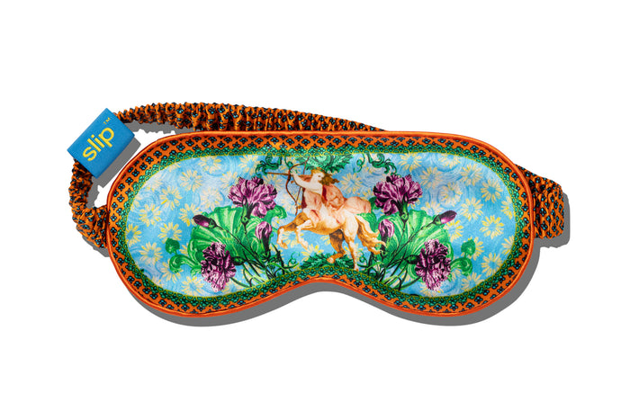 A slip silk sleep mask with a floral and horse pattern on a white background.