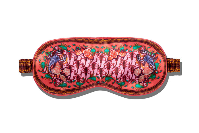 A slip Scorpio silk sleep mask with a scorpion pattern, predominantly in pink, red and purple shades on a white background