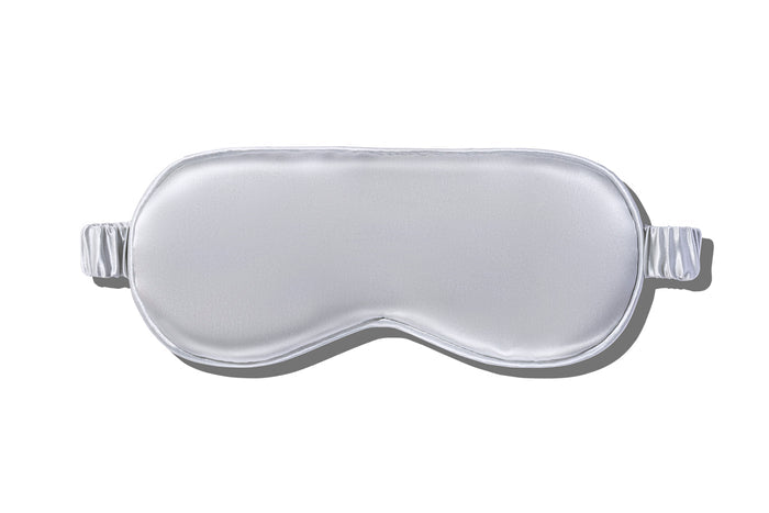 A silver slip silk sleep mask on a white background.