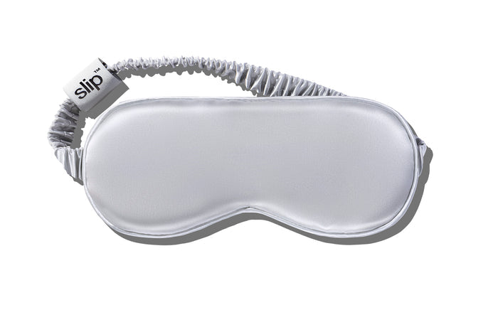 A silver slip silk sleep mask on a white background.