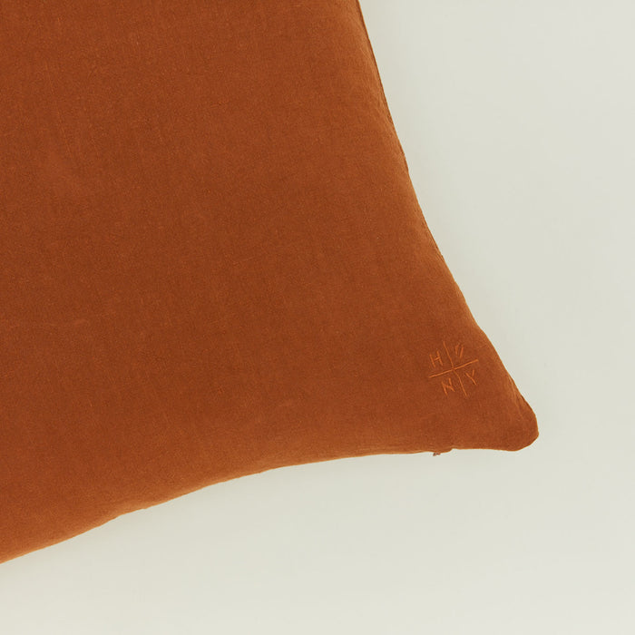 Close up view of simple linen pillow in terracotta