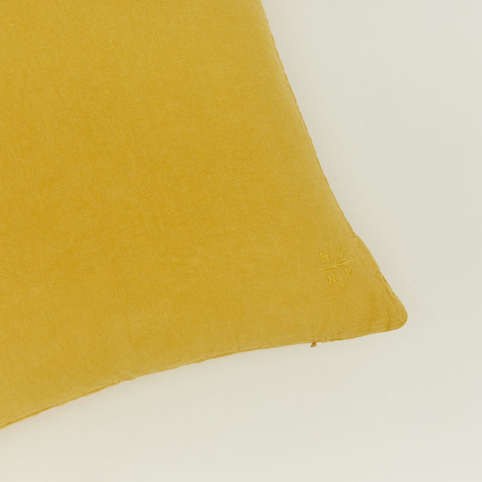 Close up view of simple linen pillow in mustard