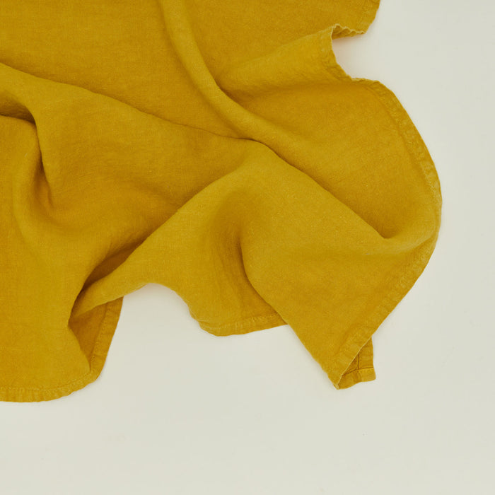 Detailed view of simple linen napkin in mustard