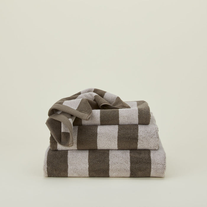 A stack of striped olive and sage terry towels in various sizes.