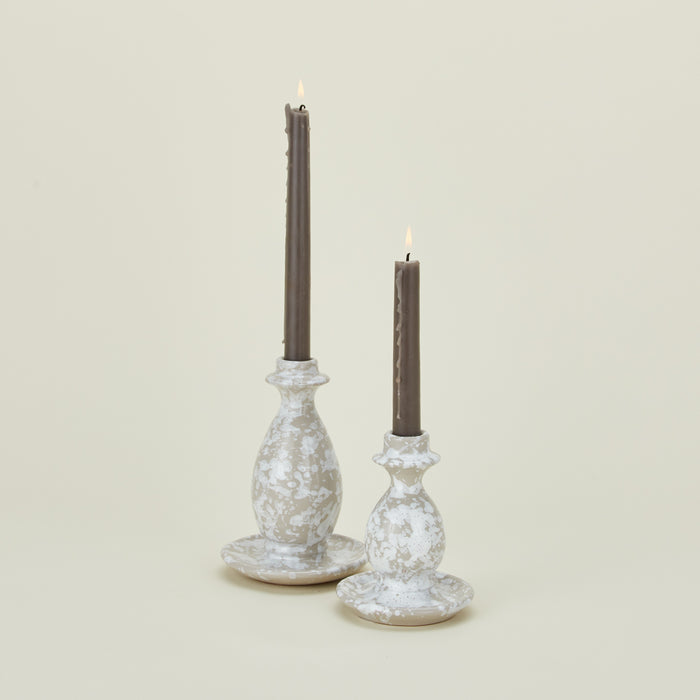 Large and small splatterware candlesticks in white and grey with candles