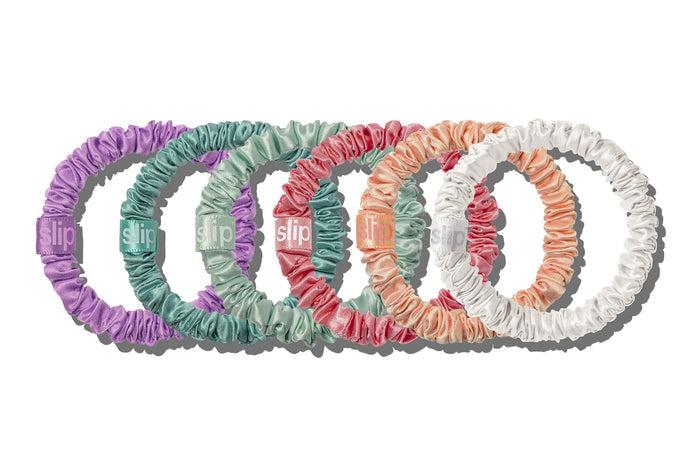 A set of 5 colorful slip silk skinny scrunchies on white background.
