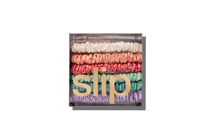 Colorful slip silk skinny scrunchies in packaging on white background.