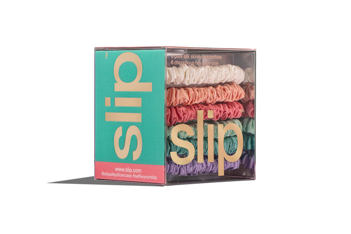 Colorful slip silk skinny scrunchies in packaging on white background.