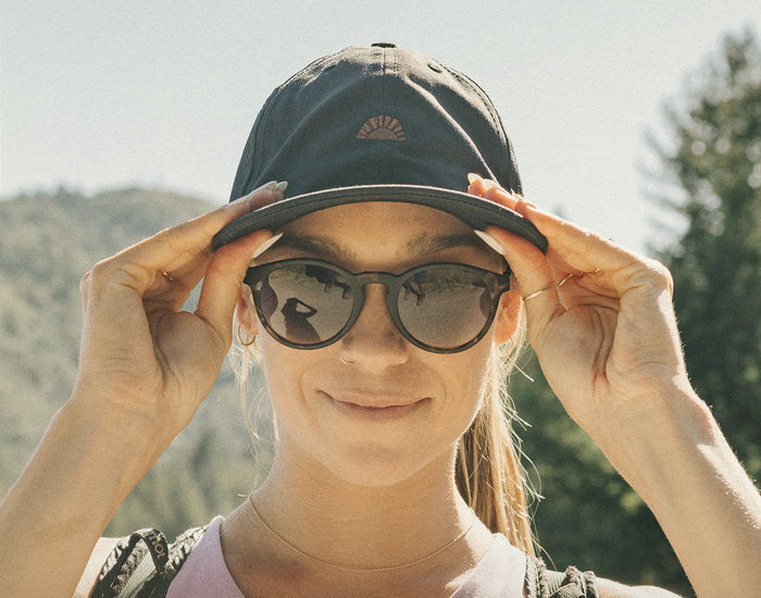STORY front angle of girl wearing sunski sunburst hat and sunglasses