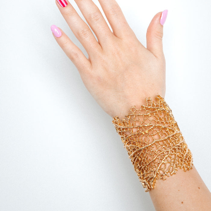 Hand with Suzy's Candy nail stickers by Maniac Nails and a gold bracelet, easy salon quality gel nails at home