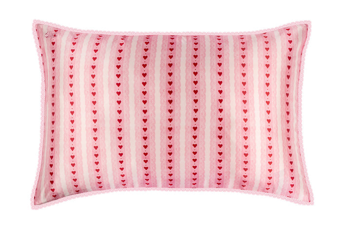 Pink pillow with heart pattern on a white background
