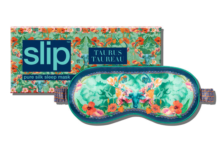 A floral-patterned Taurus silk sleep mask with packaging, predominantly in shades of blue, orange and green.