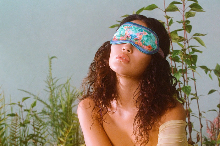 Model wearing Taurus pure silk sleep mask in a forest setting.