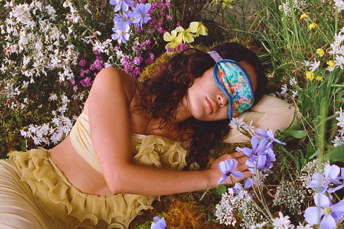 Model wearing Taurus pure silk sleep mask in a flower field.