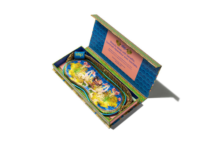 Virgo pure silk sleep mask with floral patterns, predominantly in yellow, green and blue in slip packaging.