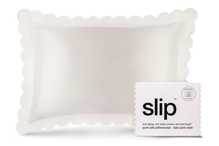 A white pure silk slip queen pillowcase with scalloped edge and invisible zipper closure, displayed with the brand packaging on white background.
