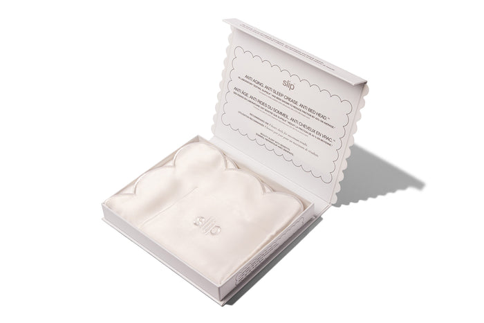 A white pure silk slip queen pillowcase with scalloped edge displayed in open slip packaging on white background.