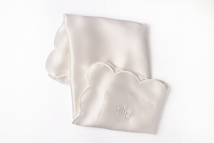 A white pure silk slip queen pillowcase with scalloped edge and invisible zipper closure on white background.