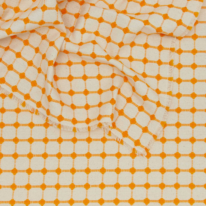 Close up view of Dove and Donkey wicker fringed tablecloth in marigold