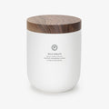 A white ceramic candle with a walnut wooden lid, labeled 'WILD SPRUCE', with scents of spruce, fresh mint, and cranberry. 10.5 OZ