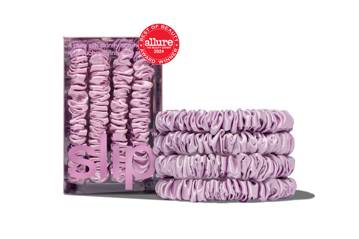 A set of four lilac silk skinny scrunchies displayed in a box and stacked in front with a allure award badge on a white background