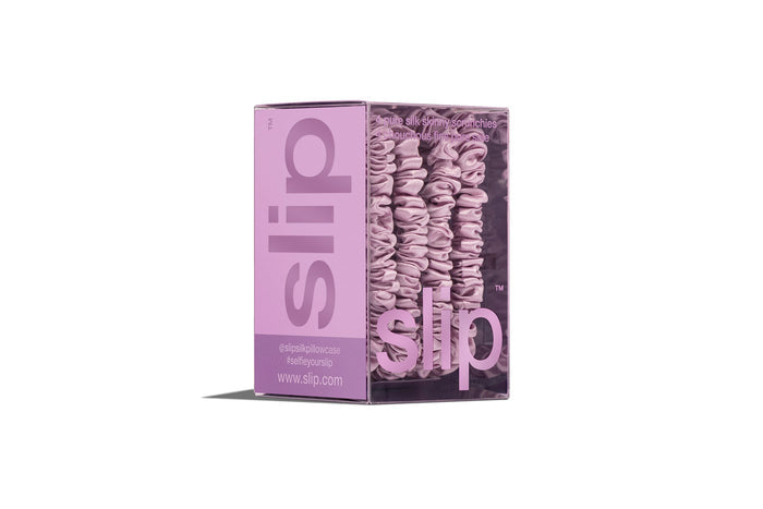Lilac silk skinny scrunchies in slip packaging on a white background.