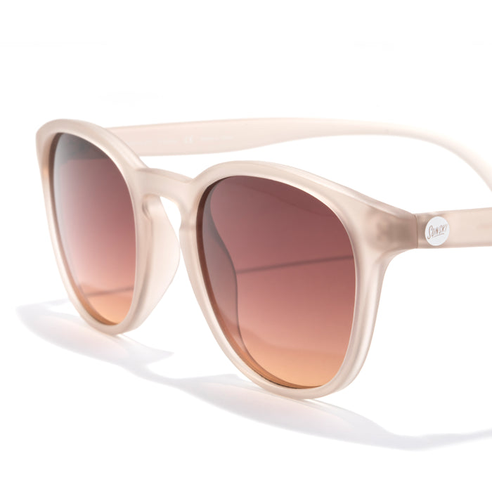 Beige sunglasses with brown gradient lenses on a white background